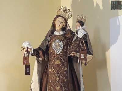 E' rappresentata su un piedistallo raffigurante una nuvola, avvolta in abiti bruni con decorazioni in oro finemente ricamate, mantello bianco e una grande corona d�oro sul capo, nell�atto di mostrare lo scapolare carmelitano. Ha in braccio il Bambino Ges�, vestito come la madre